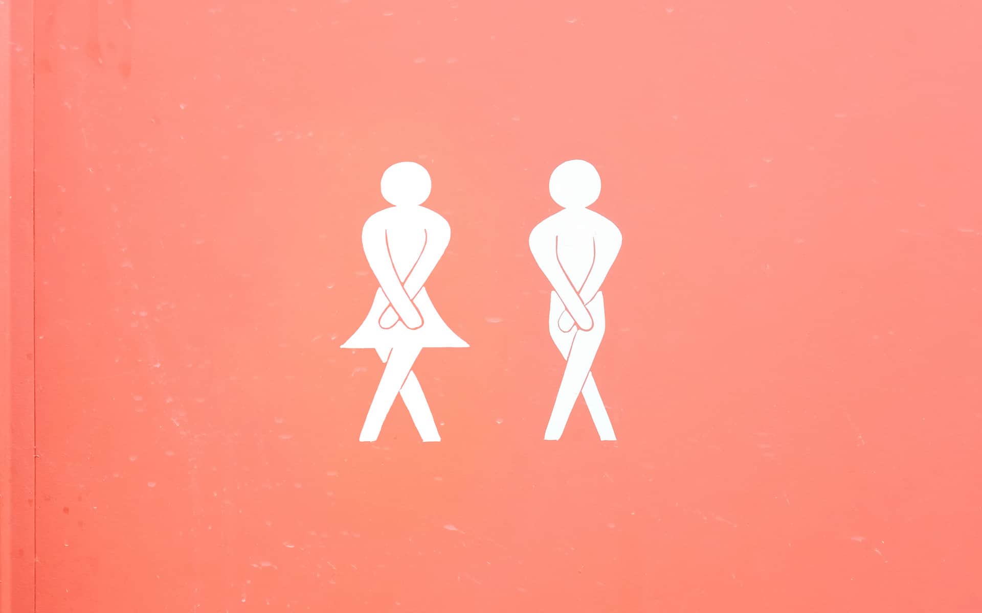 Símbolo de mujer y hombre impreso en el panel de la puerta de un baño unisex público.