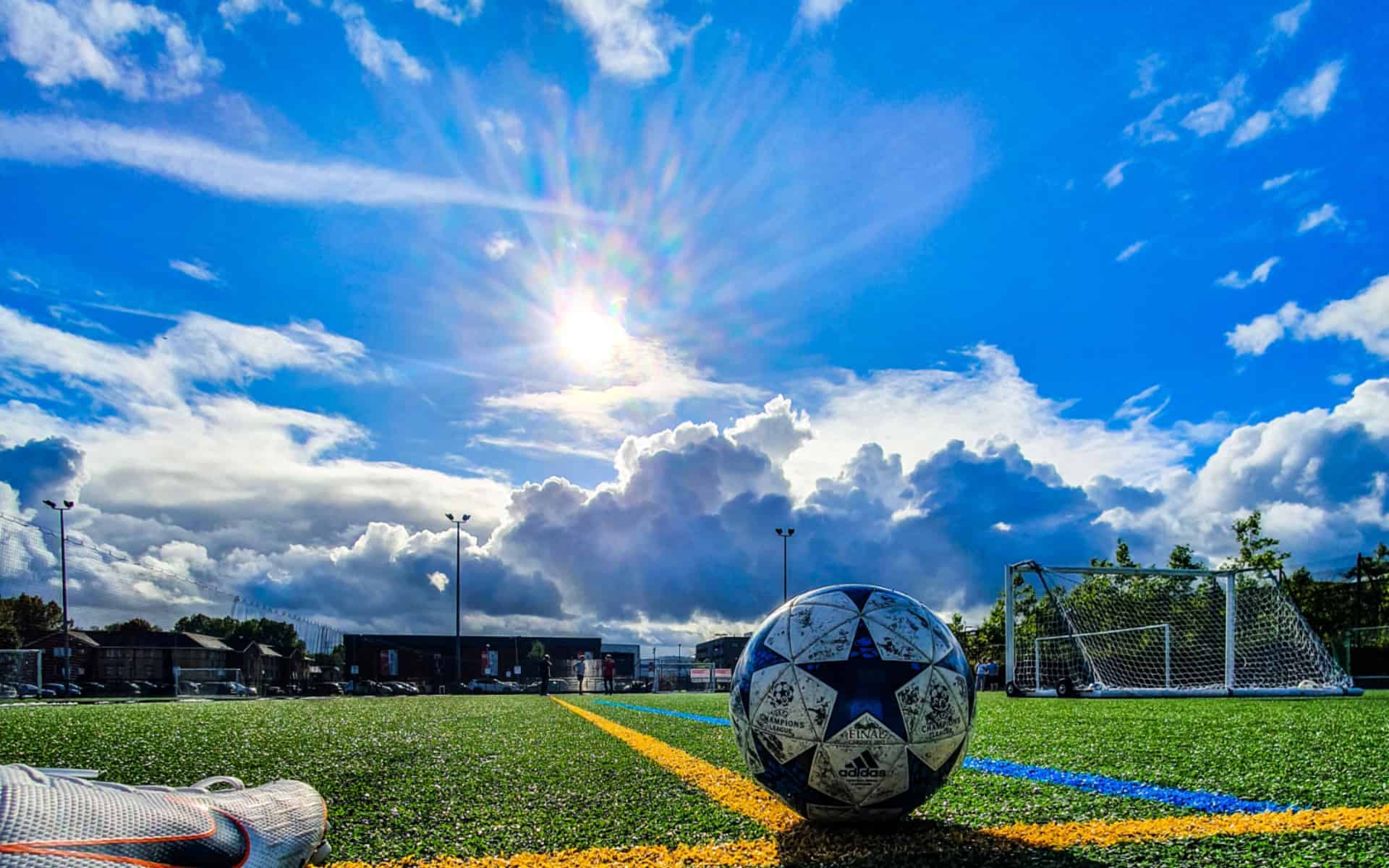Balón de fútbol con una vista de la cancha y el cielo.
