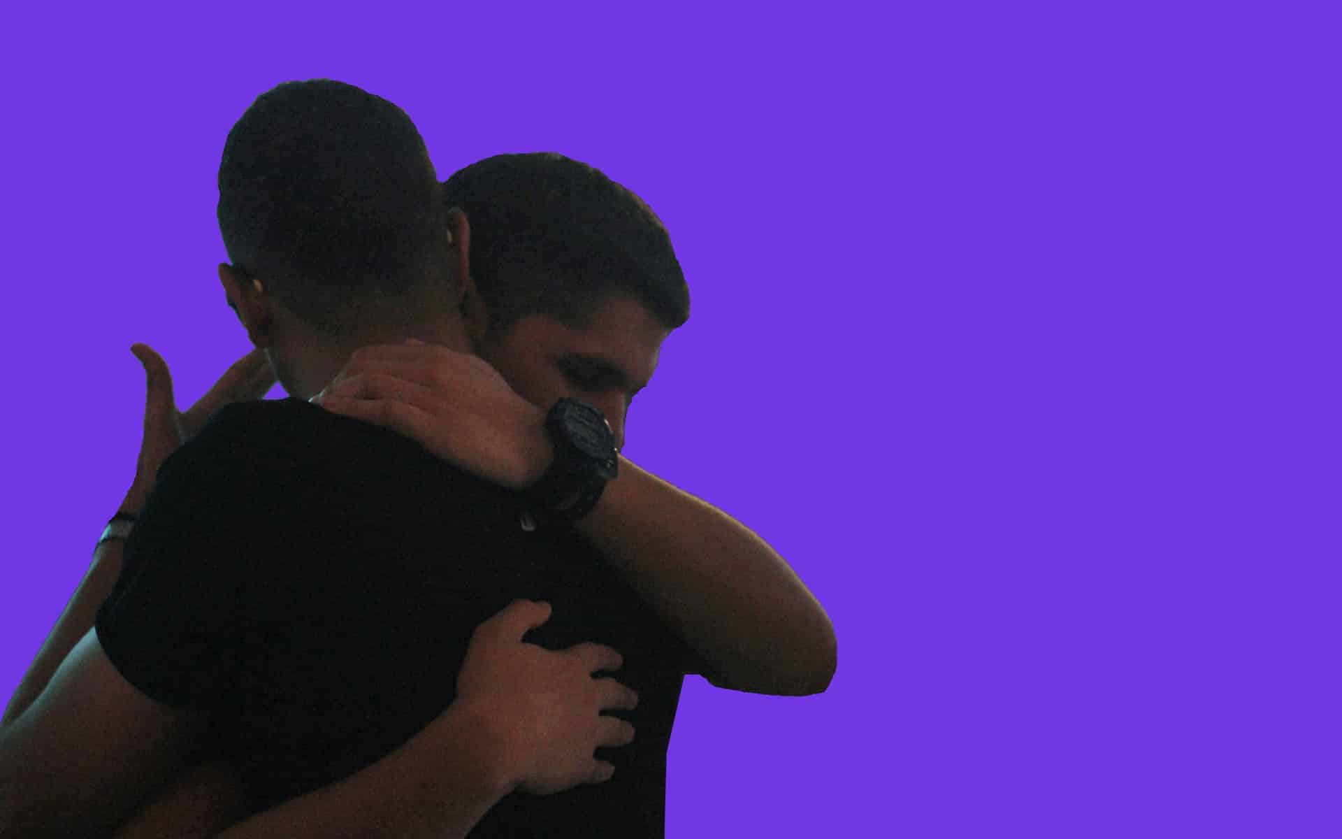 Dos hombres abrazándose.