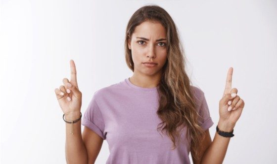 mujer joven señalando con los dedos