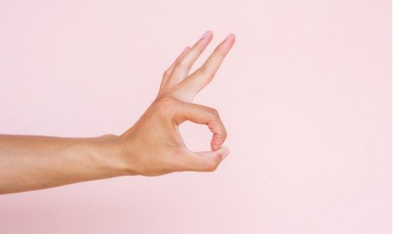 mano en fondo rosa
