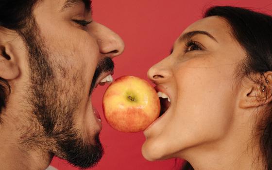 pareja mordiendo una manzana 